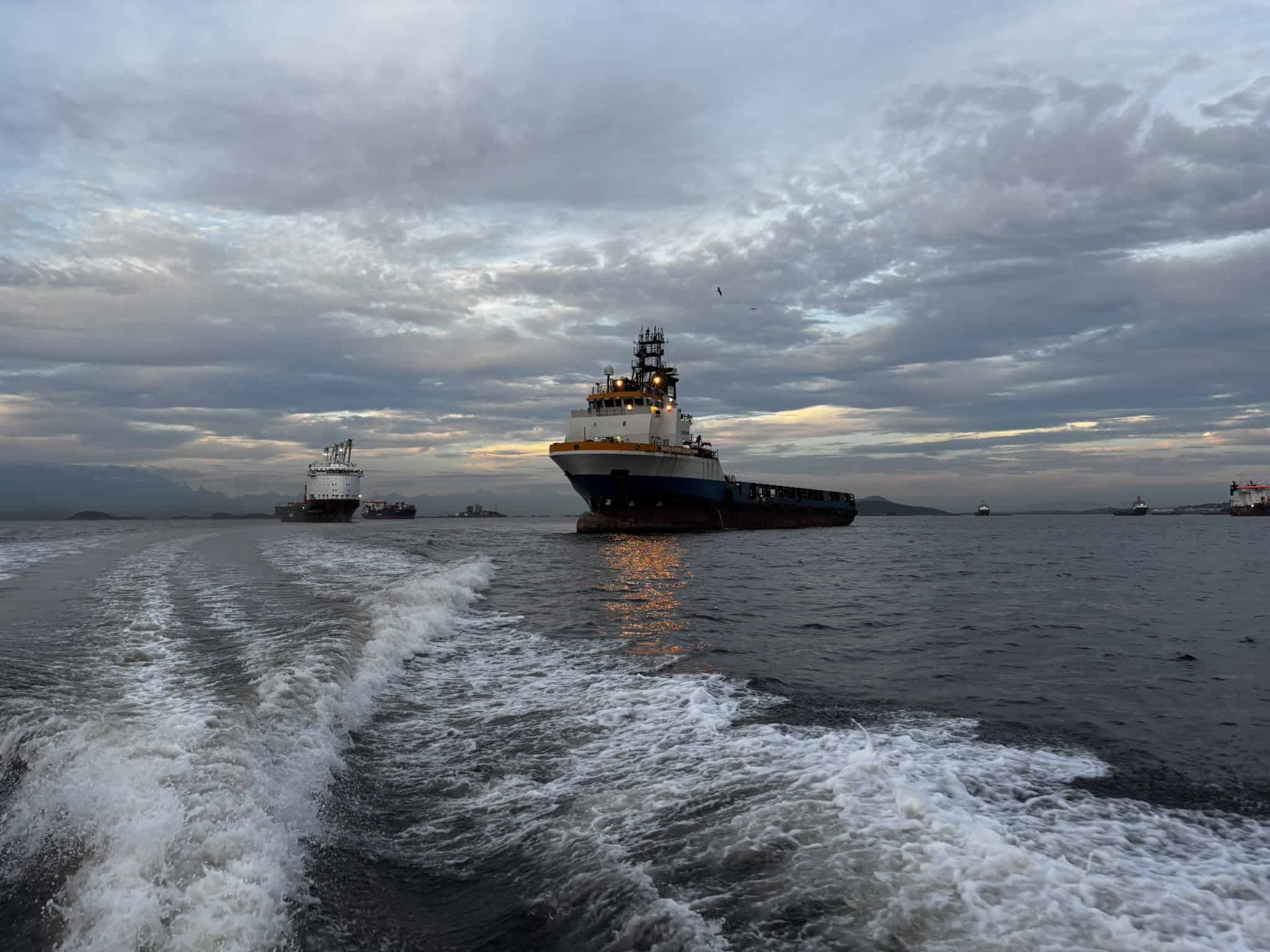 Ships on a calm sea at sunset.
